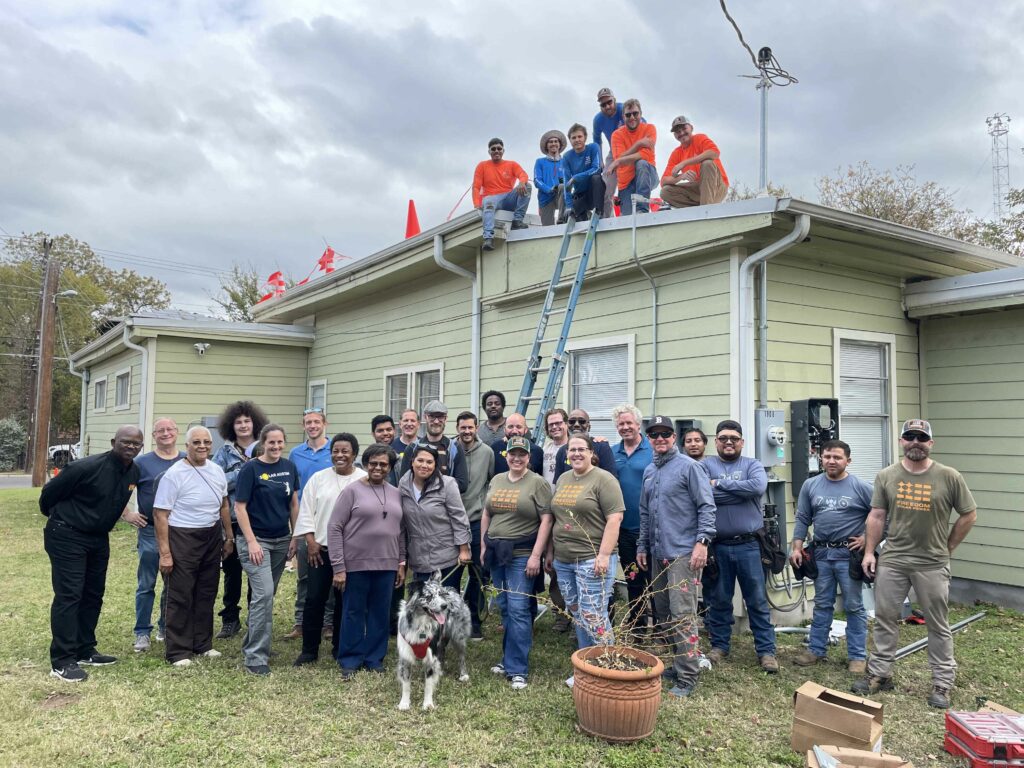 A team of The Children's Haven along with Solar Austin is posing for a photograph post solar panels installation