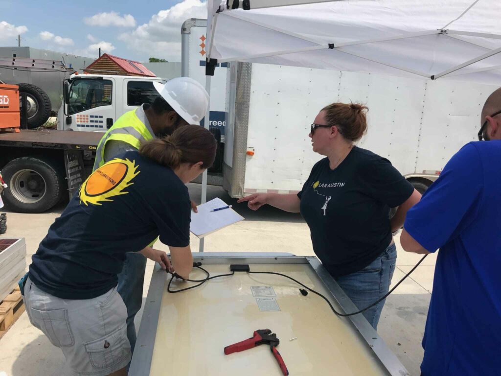 Two Volunteers from Solar Austin along with two other people working upon solar installation for Community First village